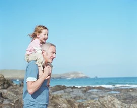 Vater trägt Kind auf seinen Schultern